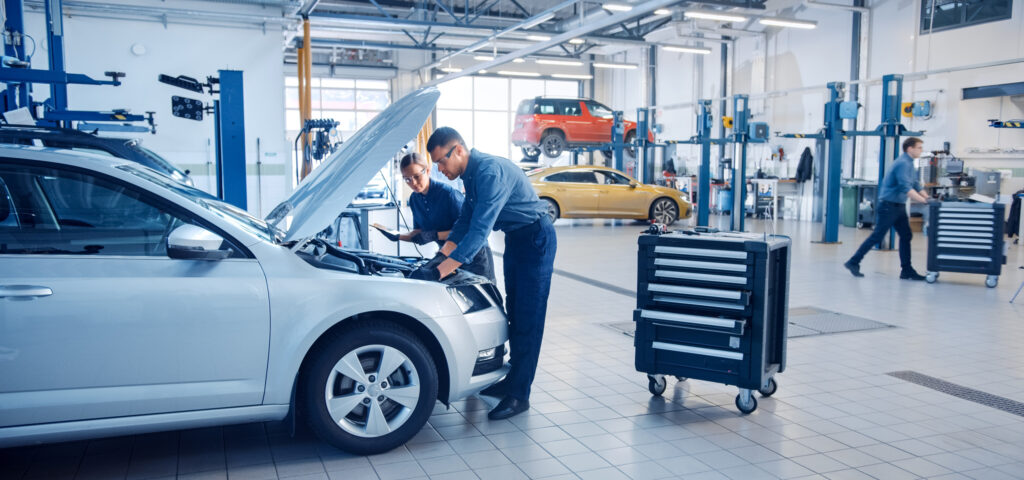 two automotive mechanics inspecting car